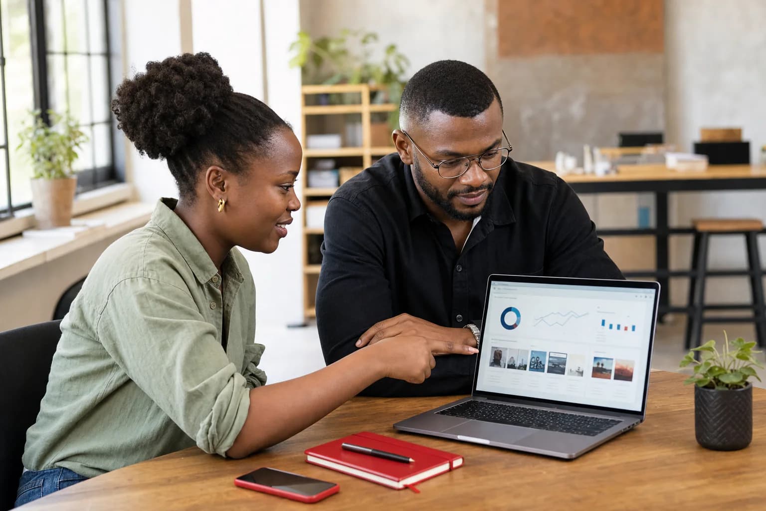 Two business professionals reviewing campaign performance on a laptop